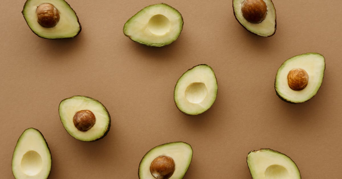 Half and half cream already curdled in a fresh carton - Avocado Fruits Cut In Half On Brown Surface