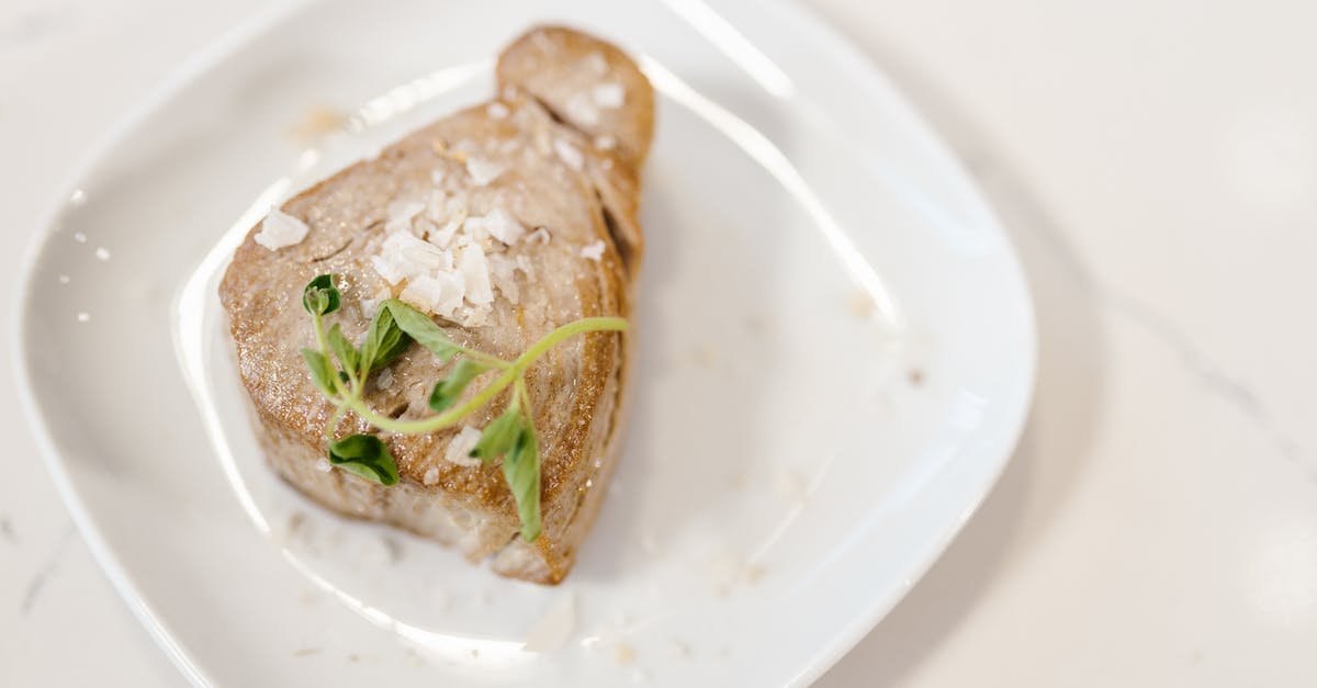 Half cooked fried fish - Chunk of Fried Tuna Fish Meat Served with Herbs on White Plate