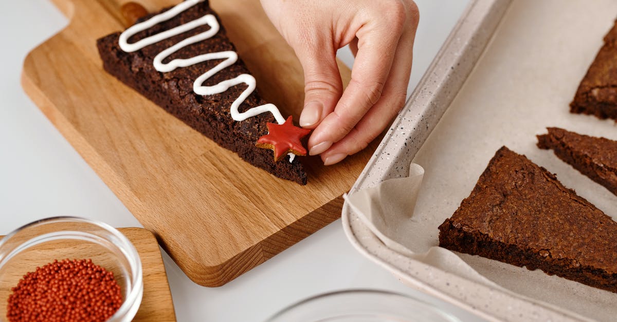 Halving Cake Recipe- Baking Time - Person Decorating a Triangle Shaped Brown Cookie