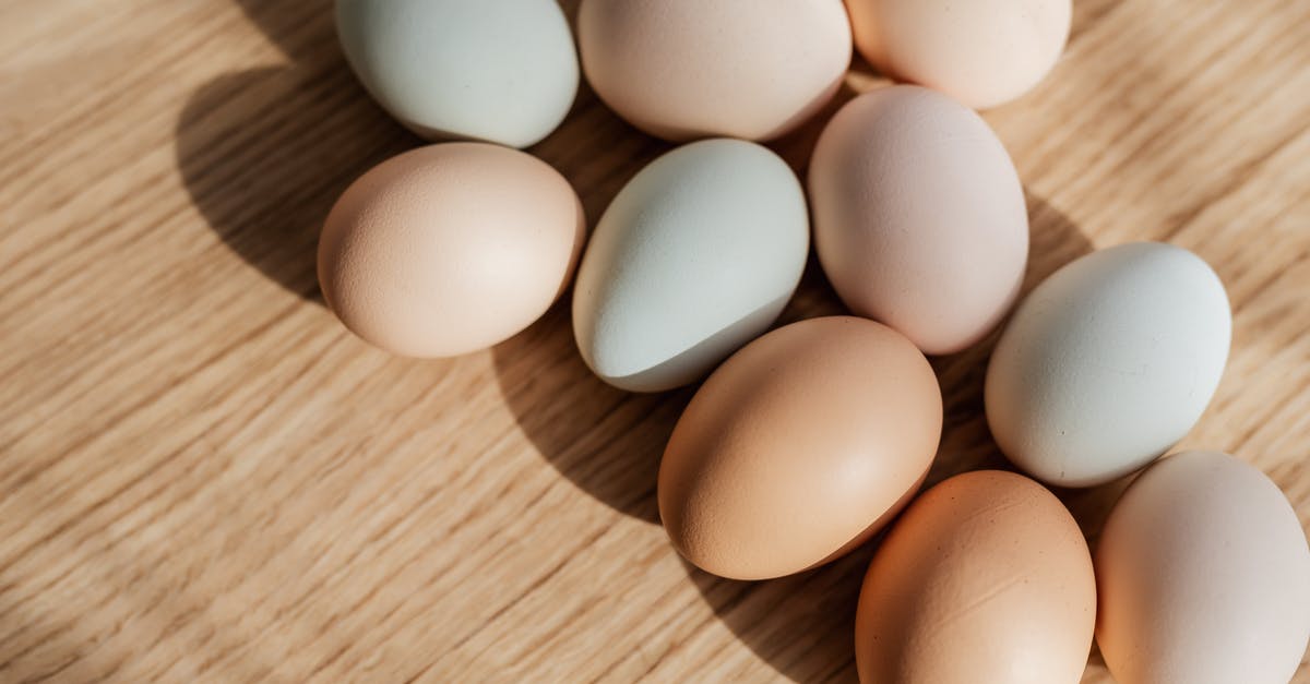 Handling raw poultry turns my cuticles black! [closed] - From above closeup of raw organic multicolored chicken eggs arranged on wooden surface in daylight