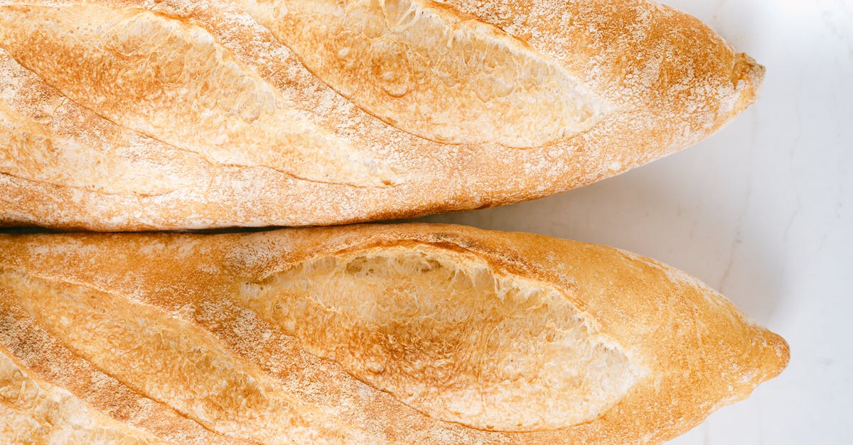 Heating part baked baguettes in lid-covered pyrex - Baguettes Bread on White Surface