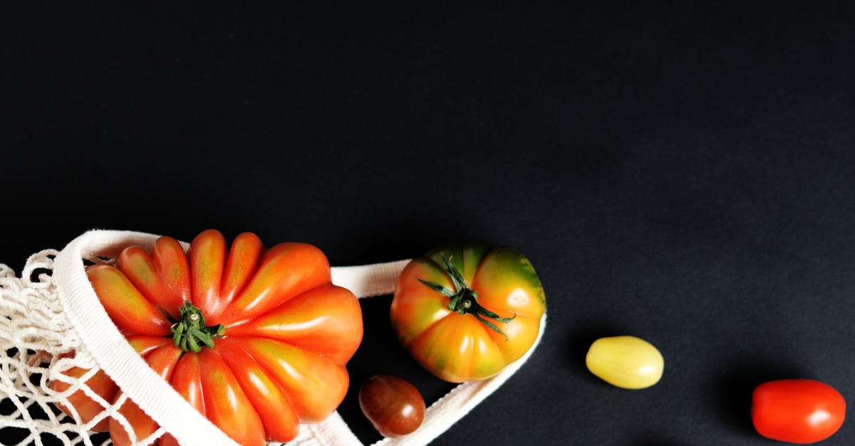 Heirloom tomatoes - Orange and Green Pumpkins on White Woven Basket