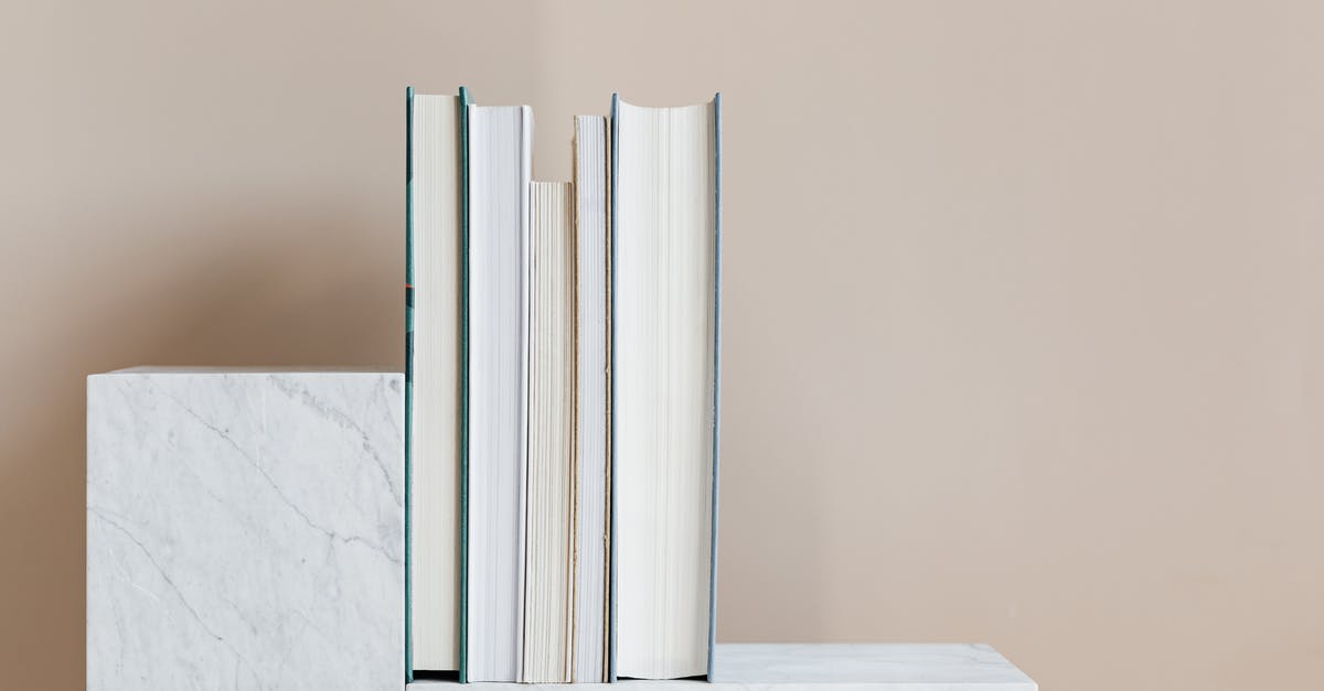 Help finding information on Marble coated woks - Geometric modern marble shelf with set of various books against beige background