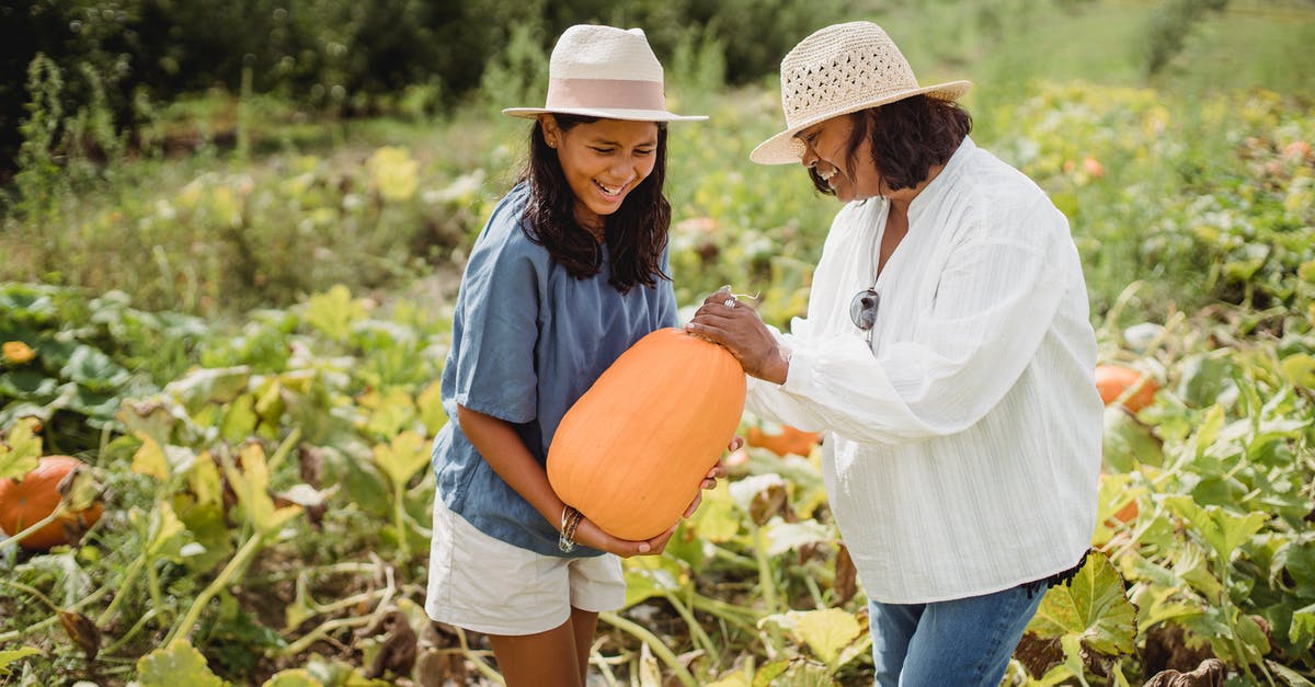 Help Identifying a pale green, spherical squash-y like vegetable - Happy Hispanic woman with daughter holding pumpkin