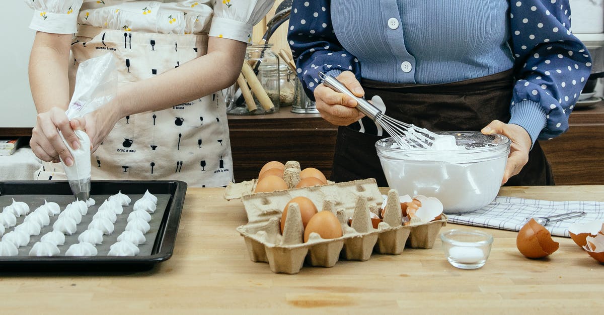 Help in identifying Scandinavian dessert recipe - Crop anonymous woman with teen preparing mixture from egg whites for sweet pastries at table in house