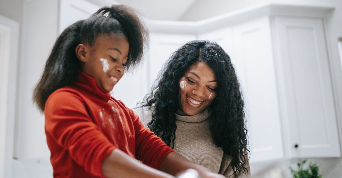 Help me duplicate Potbelly's fat-free vinaigrette - Cheerful messy African American child with flour on face cooking with parent at home