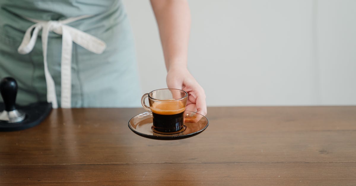 Help with finding pod-based Coffee and Espresso maker - Crop unrecognizable female barista in light green apron passing hot aromatic espresso in stylish transparent cup above wooden table