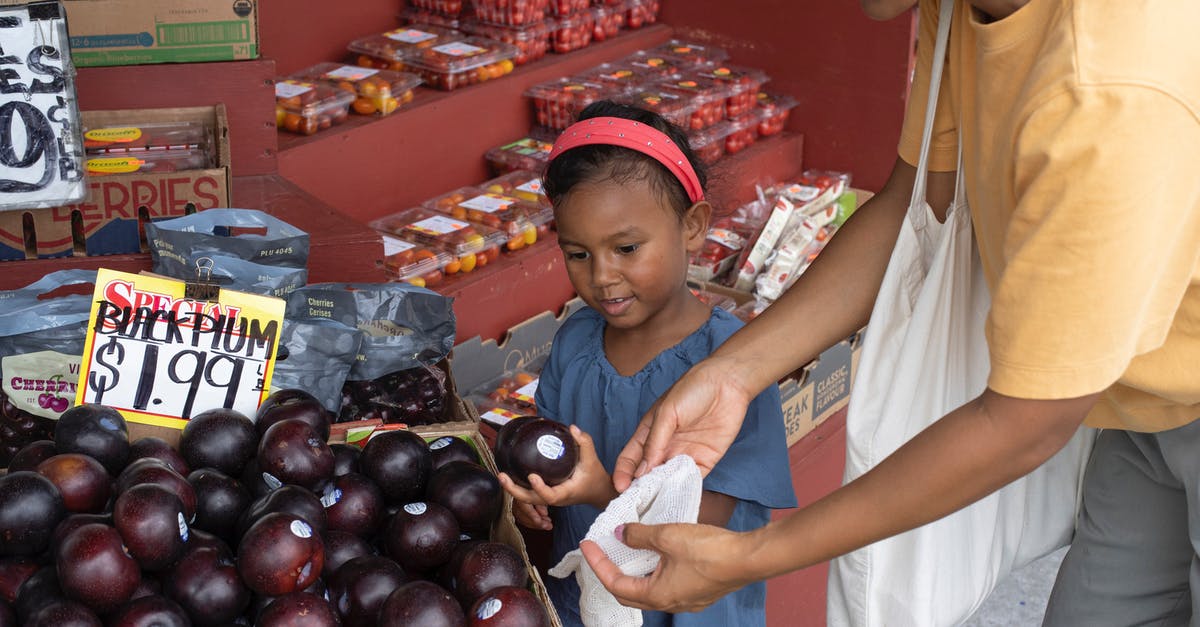 Help with friend with many allergies - Ethnic girl choosing fruit in market with mother