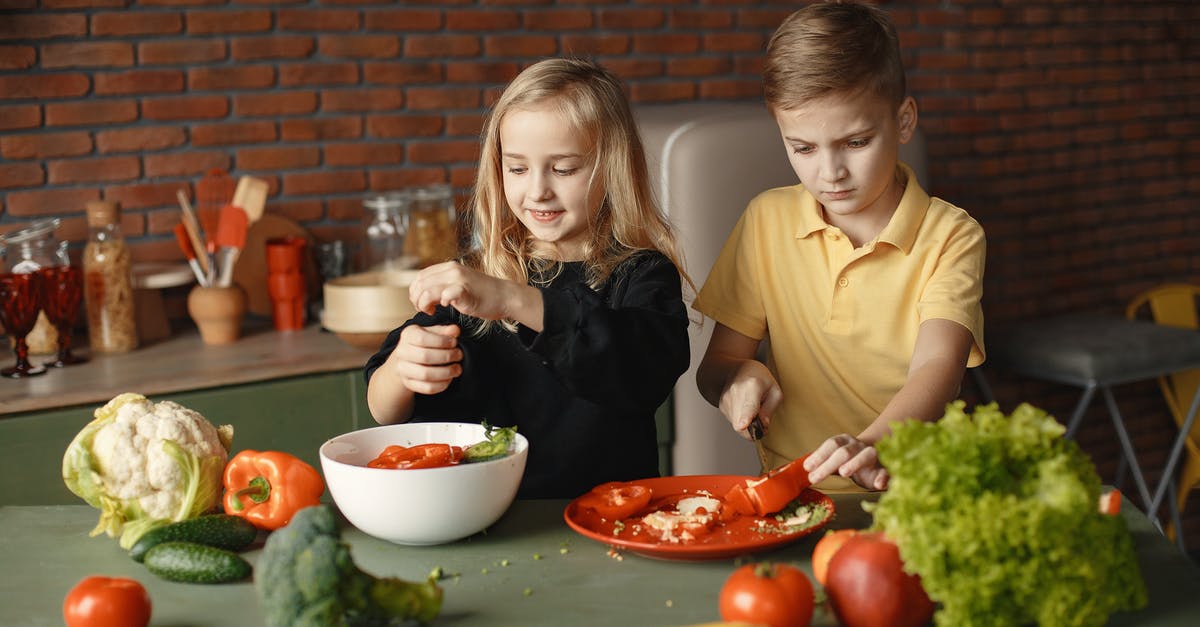 Help with seasoning cast iron wok [duplicate] - Children preparing vegetable salad in kitchen at home