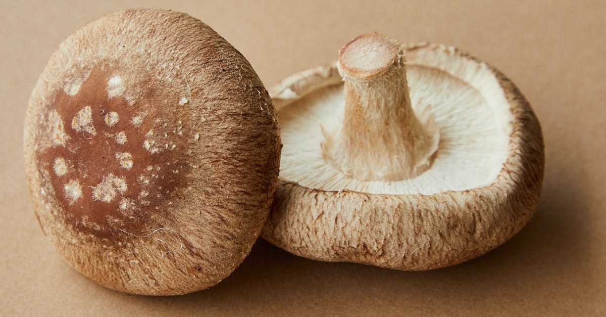 Highest protein-dense, low fat, raw, plant-based ingredient? [closed] - High angle of delicious raw mushrooms with spotted caps placed on light brown background