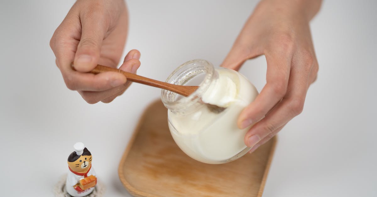 Homemade plain yogurt - Crop man taking natural yogurt with spoon from jar