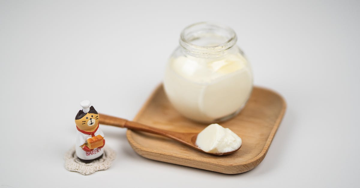 Homemade plain yogurt - Jar with delicious plain yogurt and wooden spoon on saucer