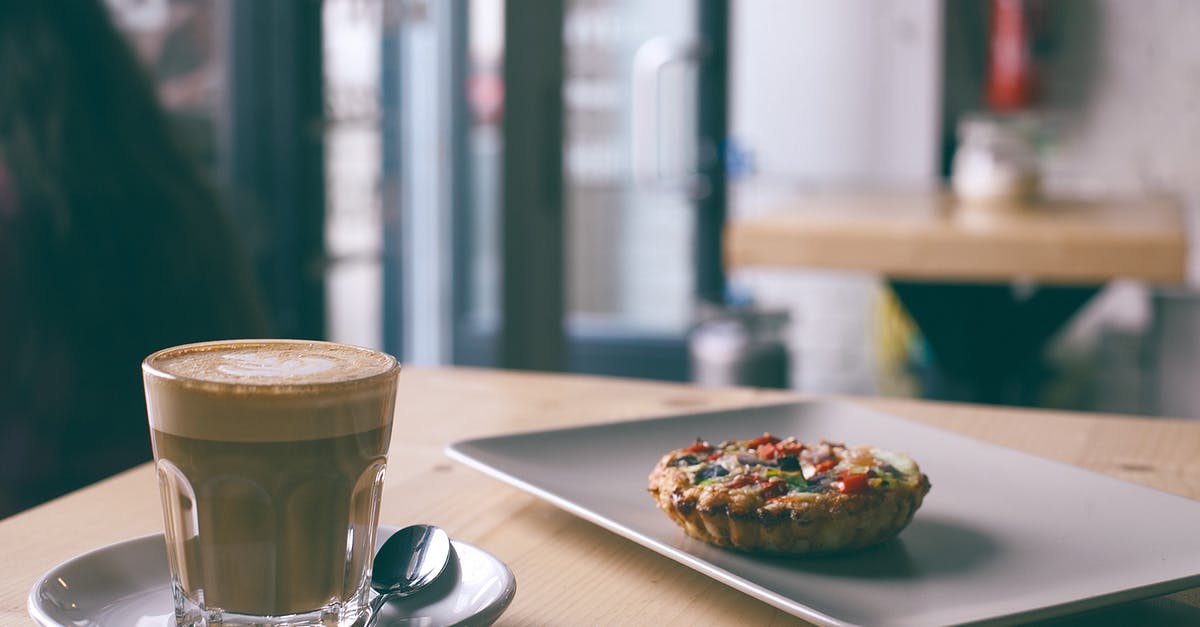 Homogenizing whole milk, butter, and vodka - Glass of cappuccino near tasty frittata in cafe