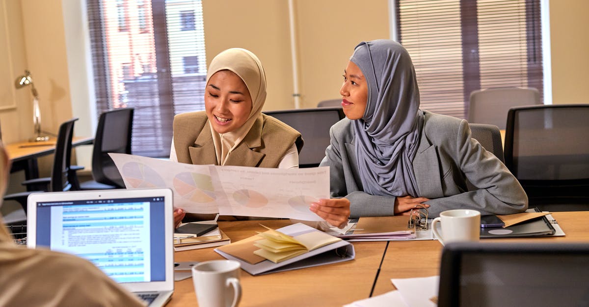 How about a Gouda soufflé? - Muslim Female Colleagues Talking About Task in Office Room