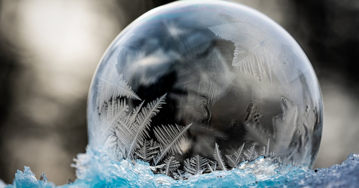 How are chemical leaveners affected by moisture and cool temperature? - Frozen clean transparent bubble with patterns on ice in winter forest on blurred background