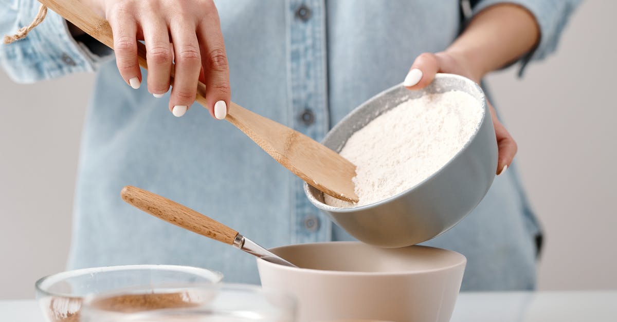 How are powdered emulsifiers (such as monoglycerides) prepared for use in cooking and baking? - Person Adding Flour into a Bowl