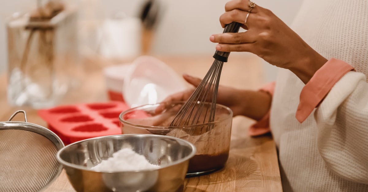 How best to melt and reform chocolate - Side view of crop anonymous African American female whisking melted chocolate near metal bowl with flour in kitchen