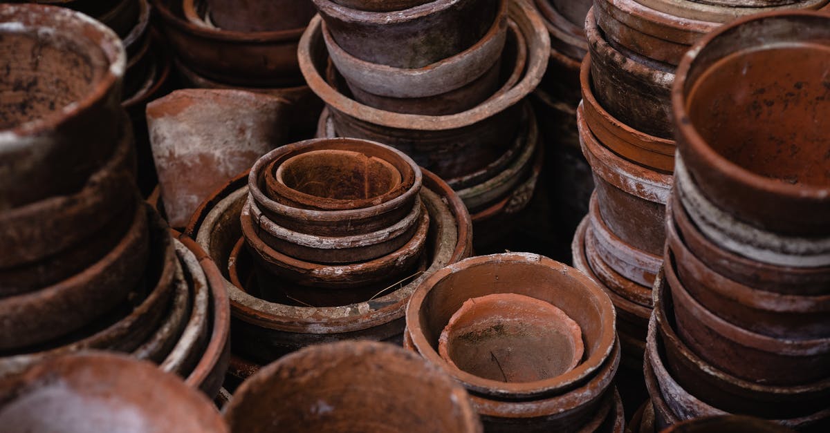 How can brown stains be removed from pots and pans? - HIgh Angle Photo of Pile of Brown Round Clay Pots