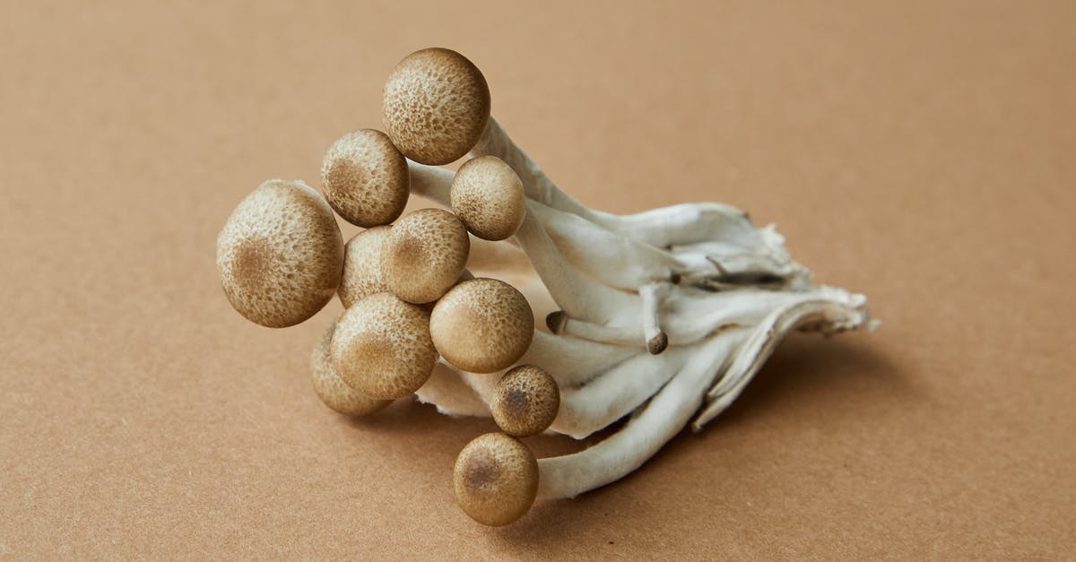How can I avoid from turning mushrooms brown while freezing it? - High angle of fresh uncooked edible light brown shimeji mushrooms on brown background