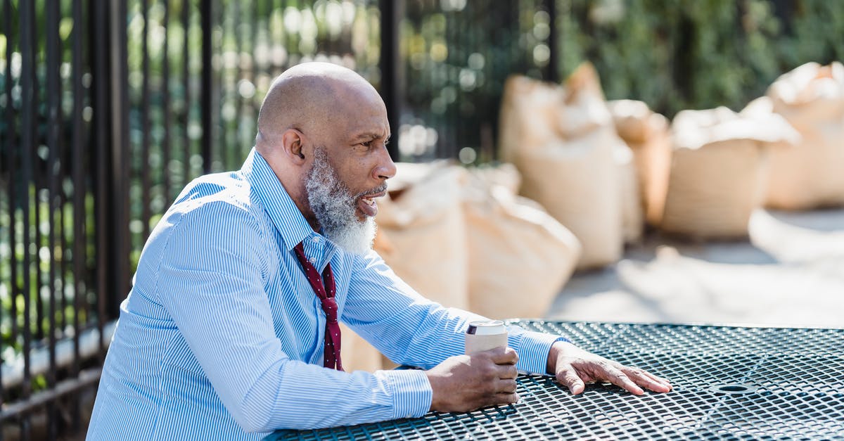 How can I avoid my patties bulging in the middle? - Side view of concerned African American male entrepreneur in formal clothes with can of alcohol beverage sitting at table on street