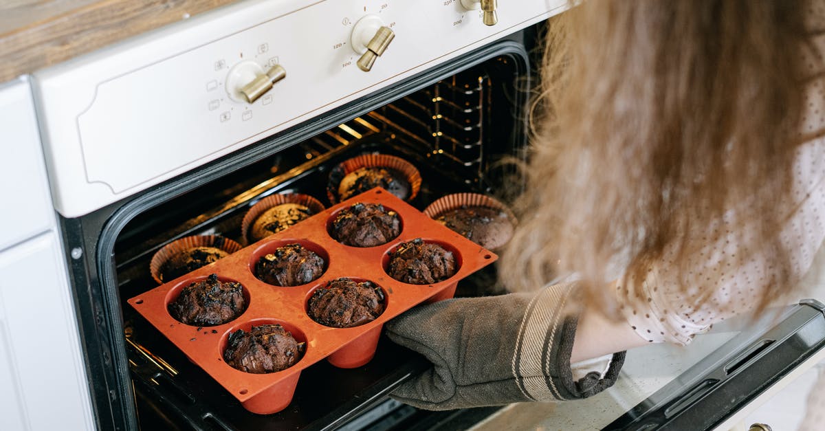 How can I avoid windswept muffins in a convection oven? - A Person Holding a Baking Tray