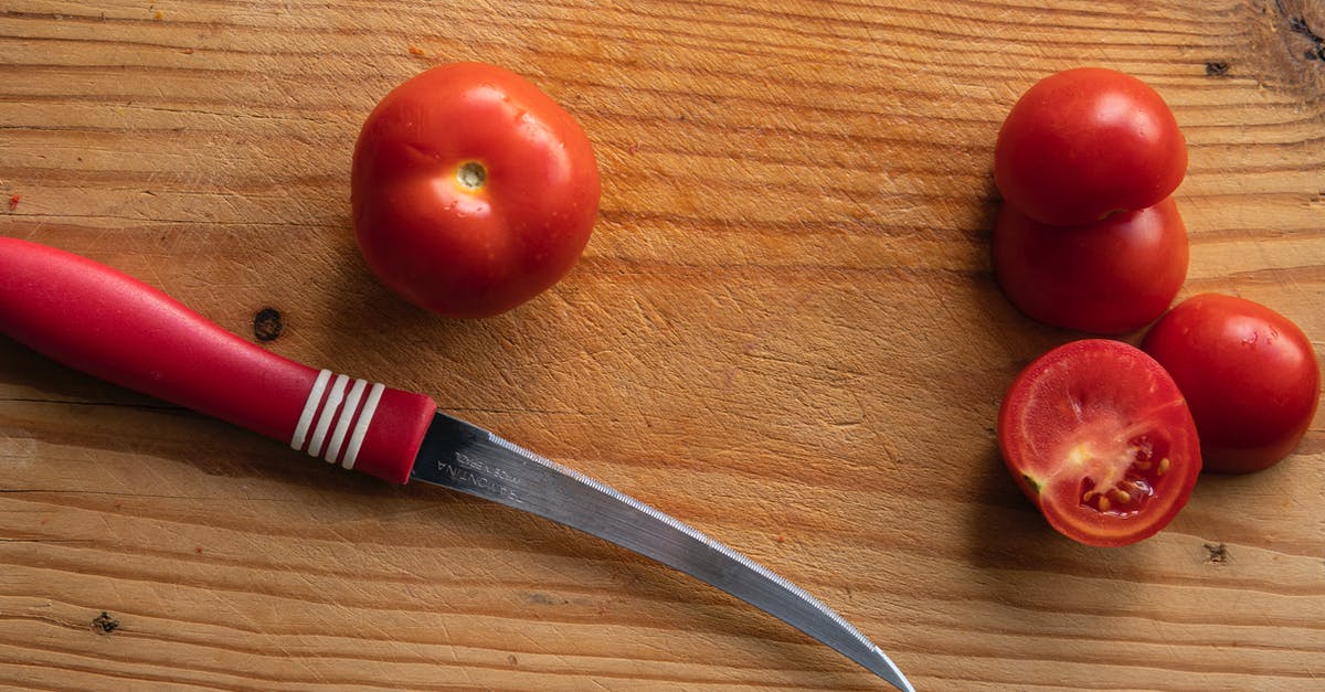 How can I clean utensils (e.g., knives) used to cut longkongs? - Knife with fresh tomatoes on wooden board