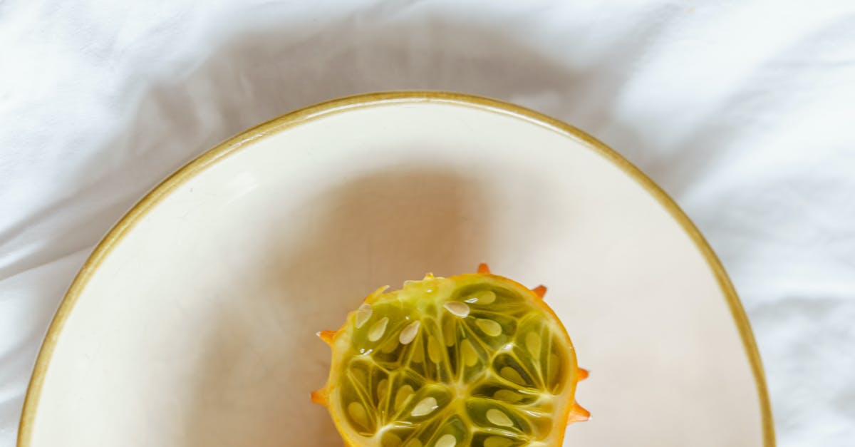 How can I concentrate citrus juice at home? - Top view of fresh kiwano on white plate on fabric in light room