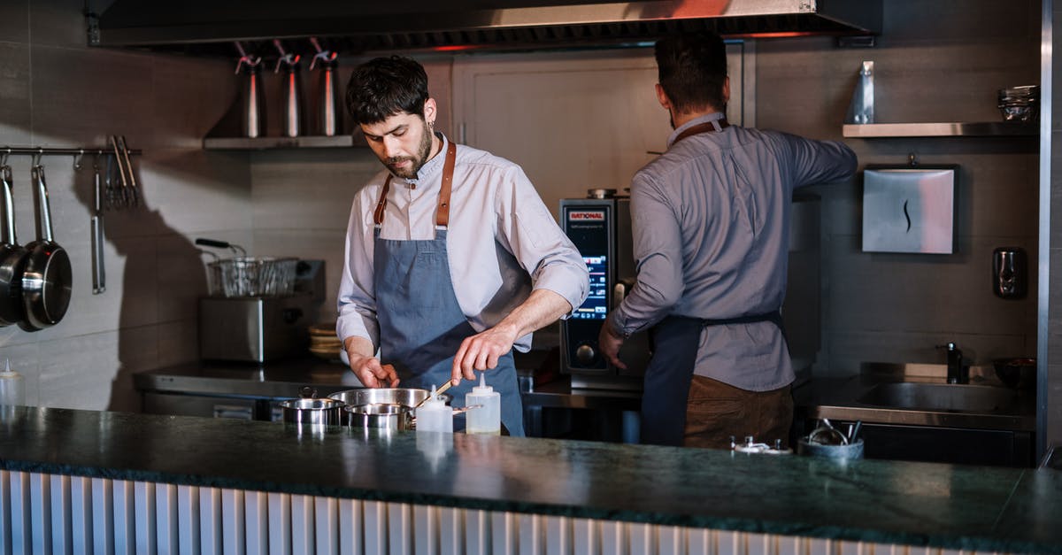 How can I cook a perfect deep-fried Mars bar? - Man in White Dress Shirt Standing Beside Man in Black Vest