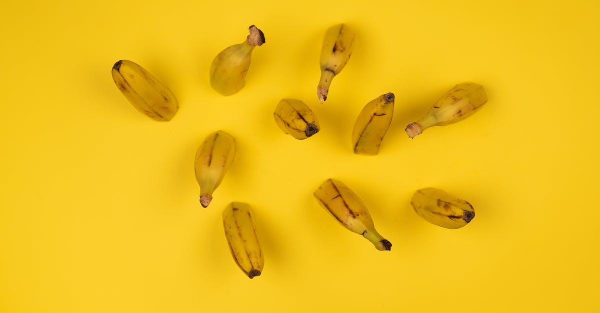 How can I cut fudge smooth and uniform? - Overhead view of delicious ripe banana halves with stems and blots on peel on yellow background