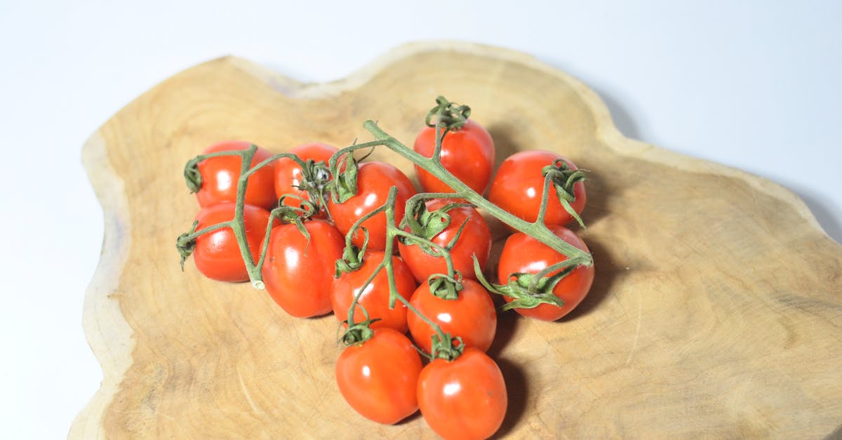 How can I dice vegetables on a small cutting board? - Tomatoes on branch placed on wooden board
