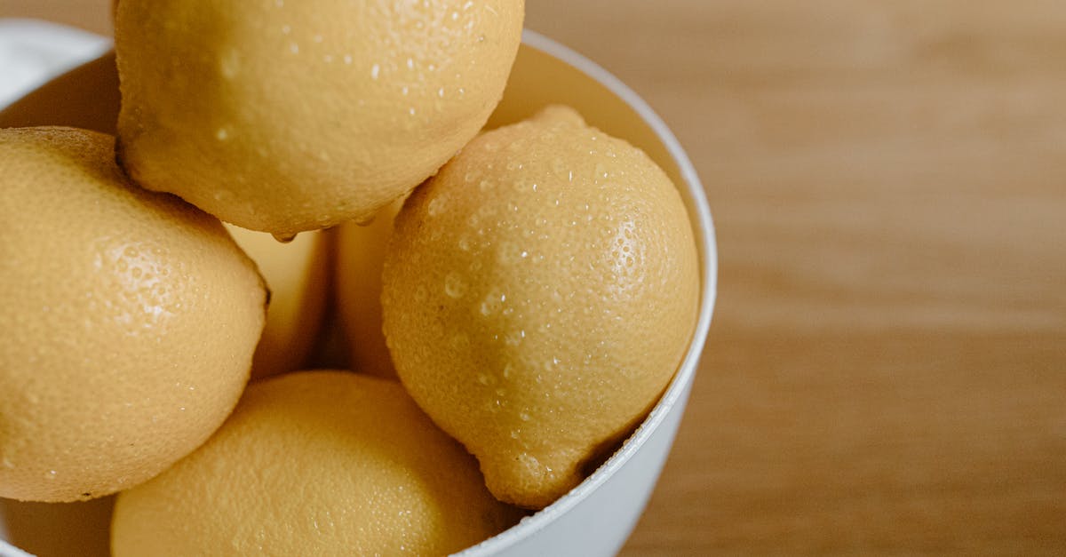 How can I easily peel baby round potatoes? - From above of clean lemons with water drops in bowl on table in kitchen