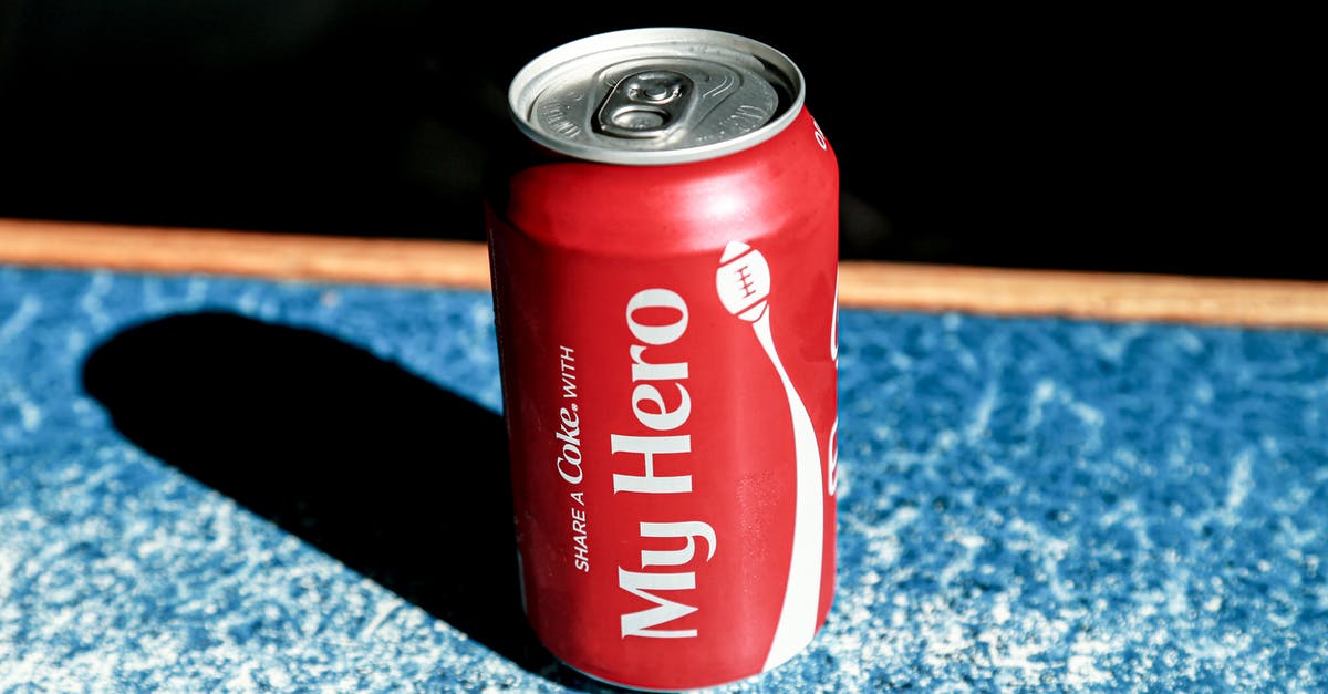 How can I extract palm sugar from a container? - From above of red metal can with refreshing fizzing coke placed on table in cafe