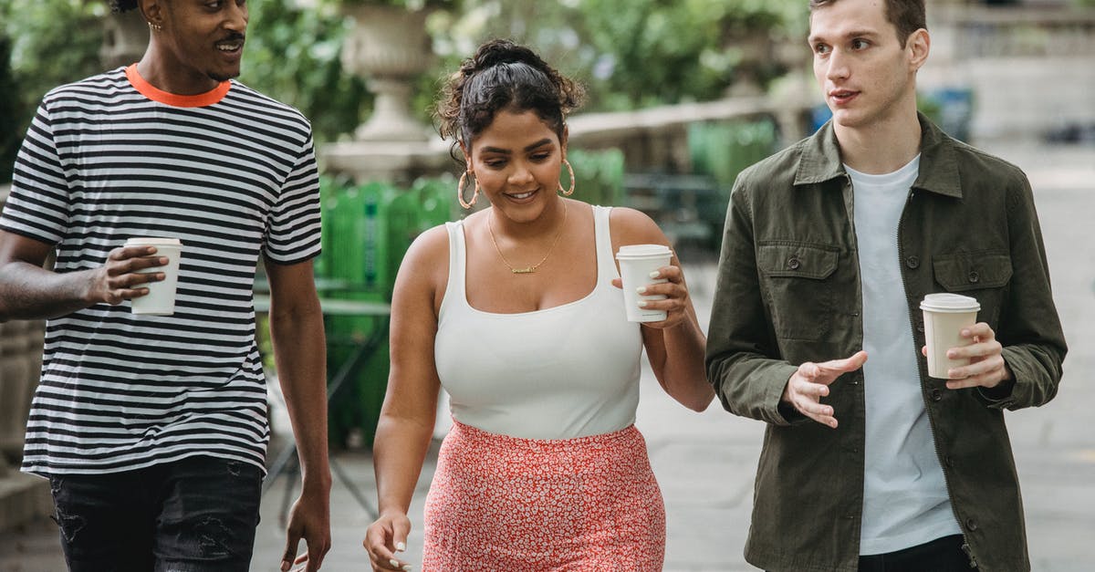 How can I get a takeaway style pizza base? - Joyful young multiethnic students in casual clothes discussing lessons while walking together in park with takeaway cups of coffee