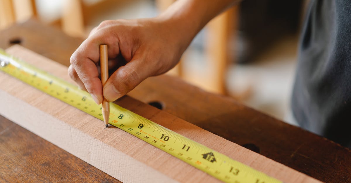 How can I improve the texture of my home-made sausages? - Man working with measurement yellow tape on wooden plank