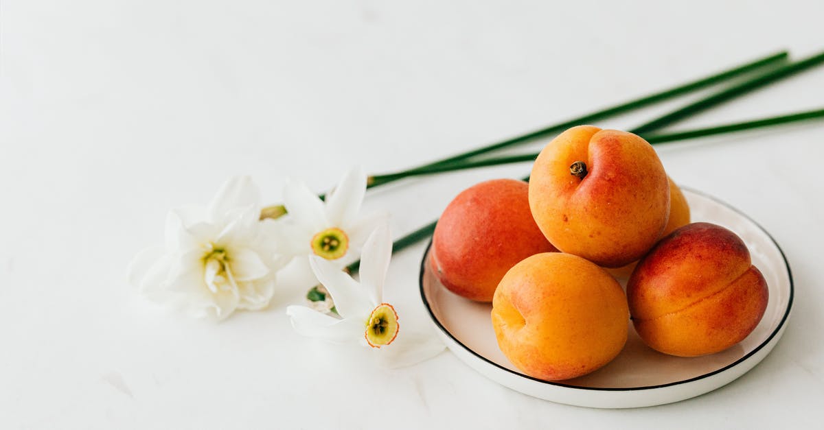 How can I keep delicate food from sticking to the grill? - From above of appetizing ripe apricots in ceramic plate composed with fresh delicate white narcissus flowers