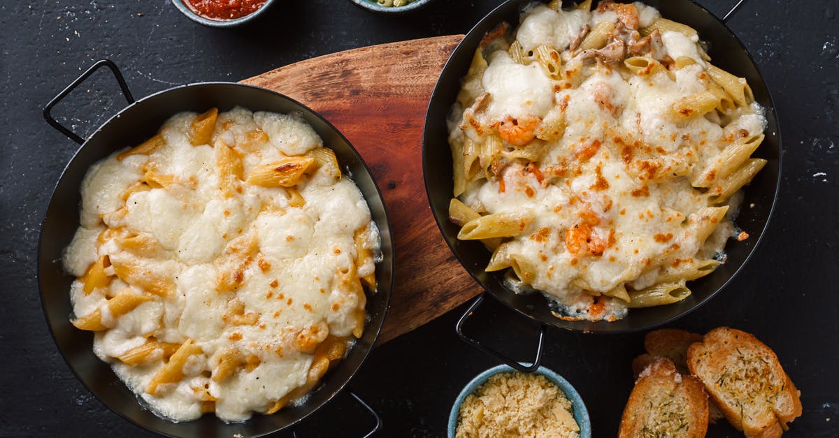 How can I keep from burning a pan sauce? - Top view of freshly prepared Italian penne pasta with cheesy sauce served in pans and placed on wooden cutting board near traditional sauces and bruschettas