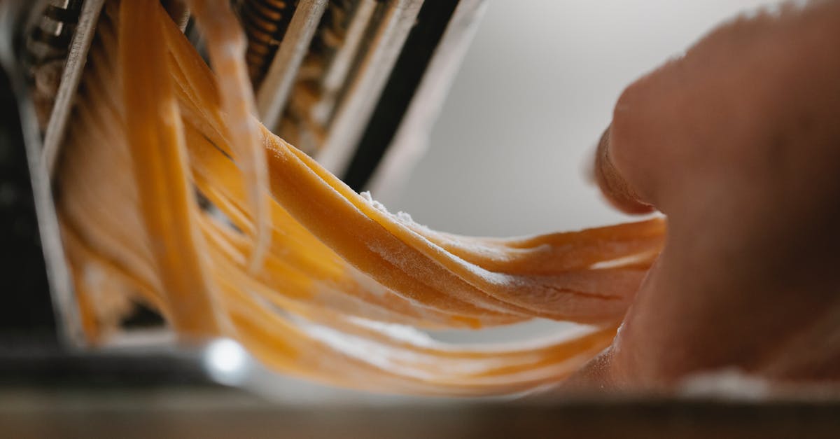 How can I make a super-thin, yet strong, calzone crust? - Person cutting noodle with pasta machine