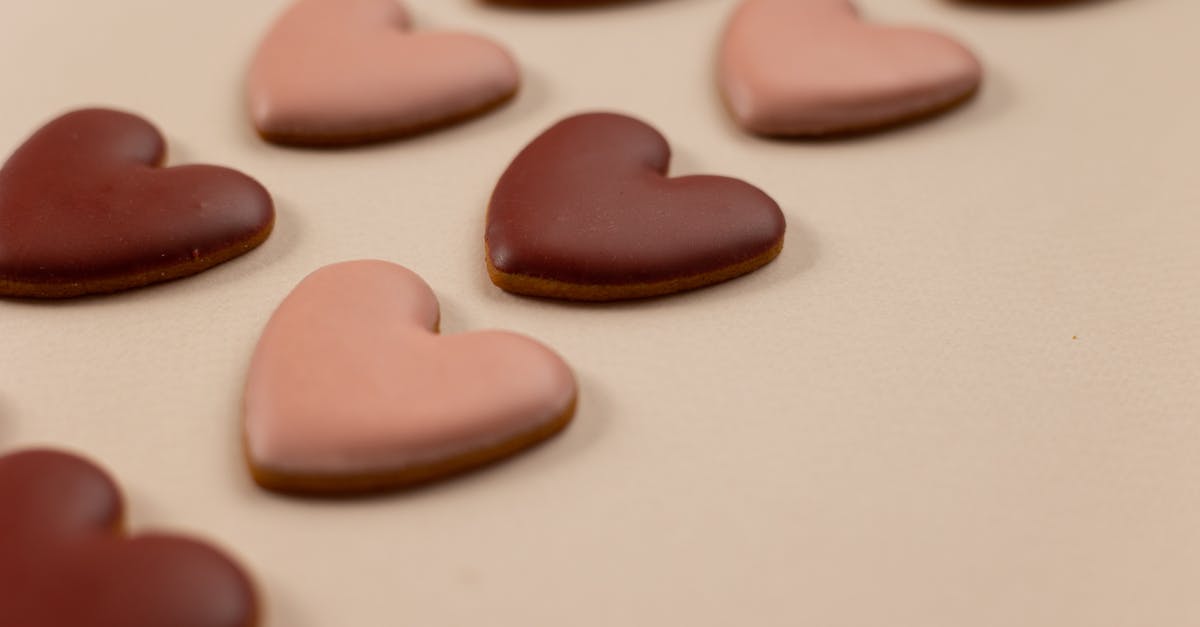 How can I make melted chocolate set faster? - From above of red and pink heart shaped cookies with frosting arranged in rows on beige background during valentines day