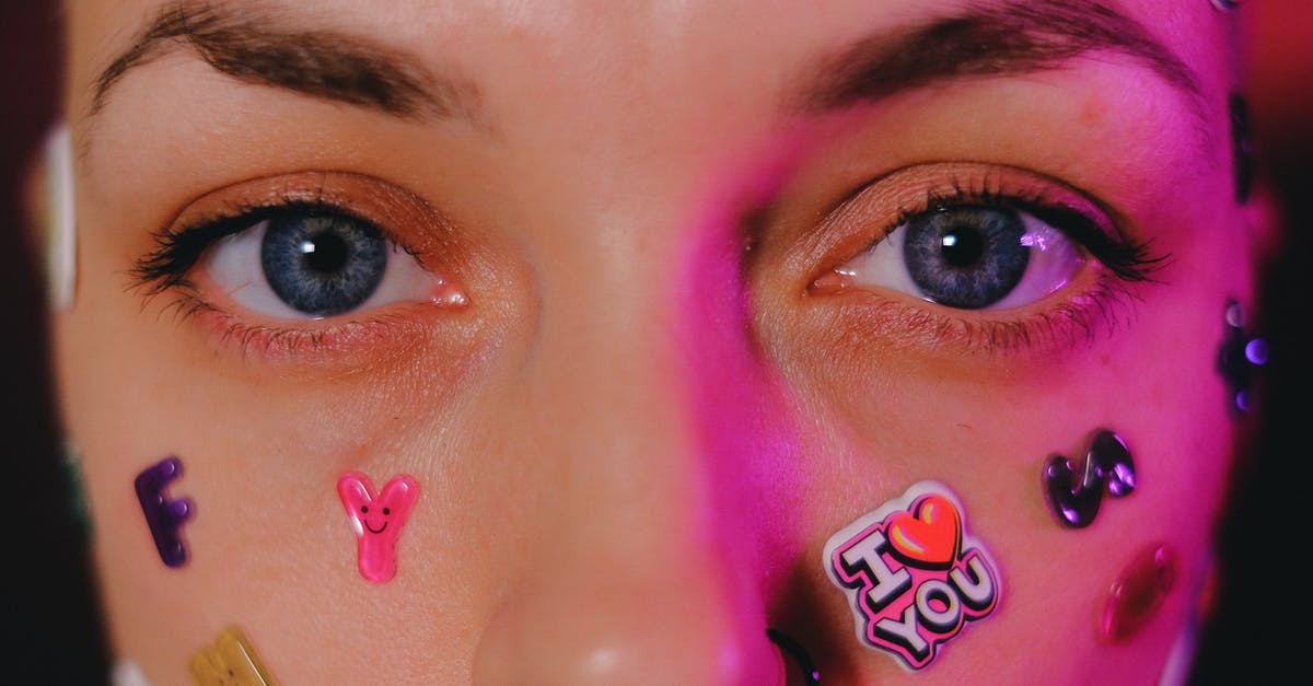 How can I make menemen look better? - Crop calm female with nose piercing and letter stickers on face standing on dark background and looking at camera