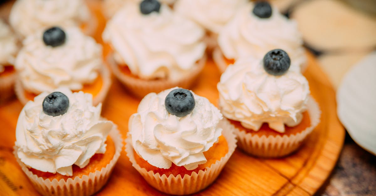 How can I portion out frozen cookie dough? - High angle of delicious cakes with creamy topping and berries placed on wooden plate on buffet table