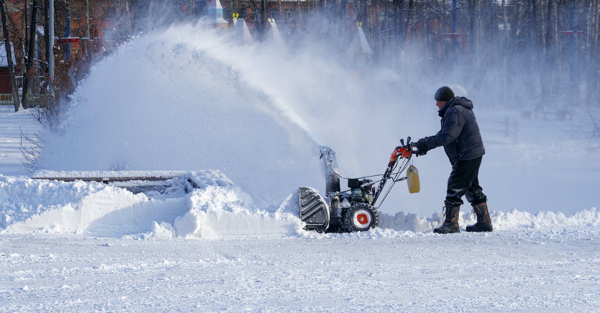 How can I remove blood from snow goose breasts within a few hours? - Full body man in warm clothes walking with snow thrower while cleaning yard in town