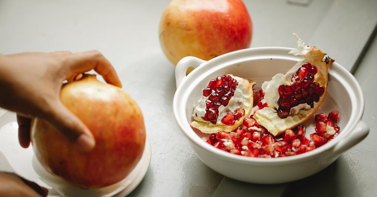 How can I remove discolouration on my ceramic dish? - Crop person with ripe pomegranate in hand