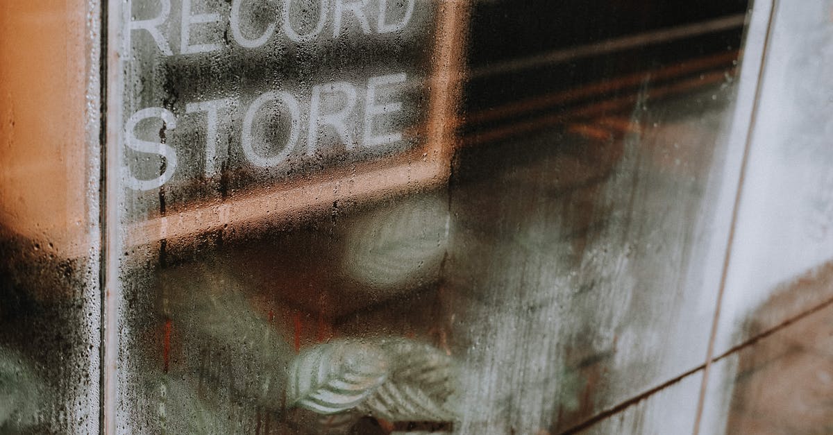 How can I safely store or dry wet sugar? - High angle of transparent glass wall with wet surface covered with water drops of record store