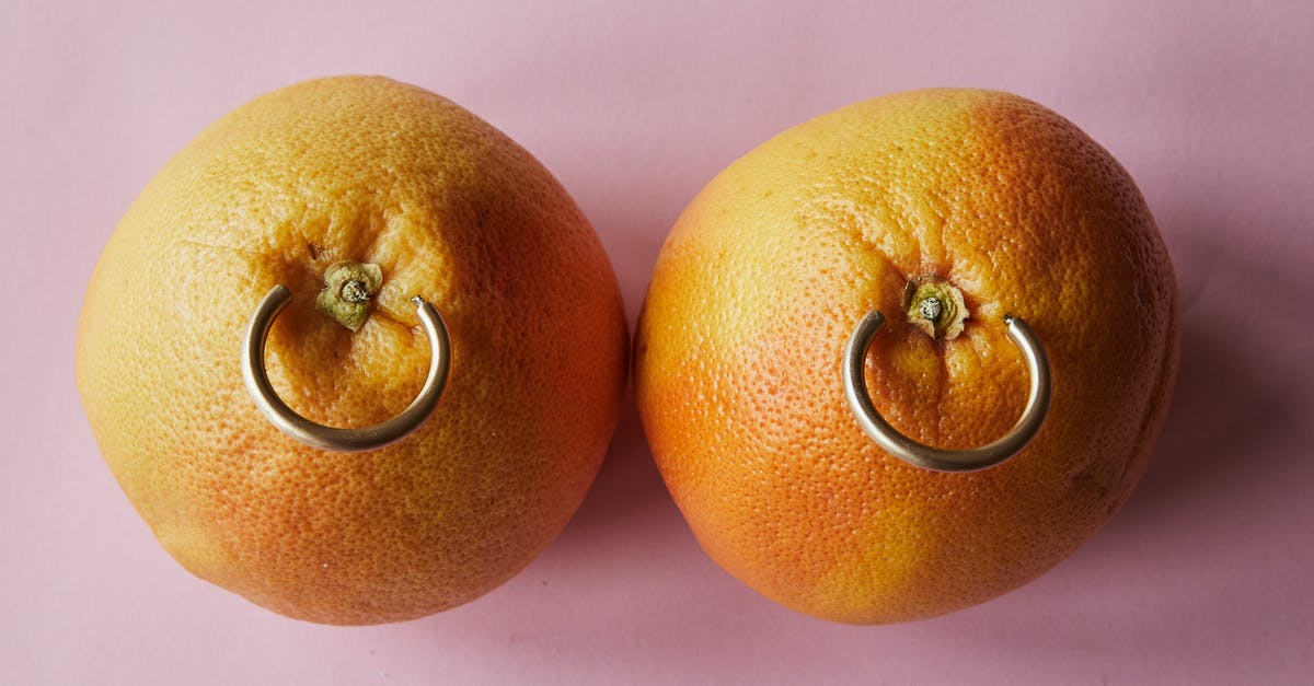 How can I tell when the wax has been removed from citrus fruit? - Fresh mandarins with earrings placed on pink surface