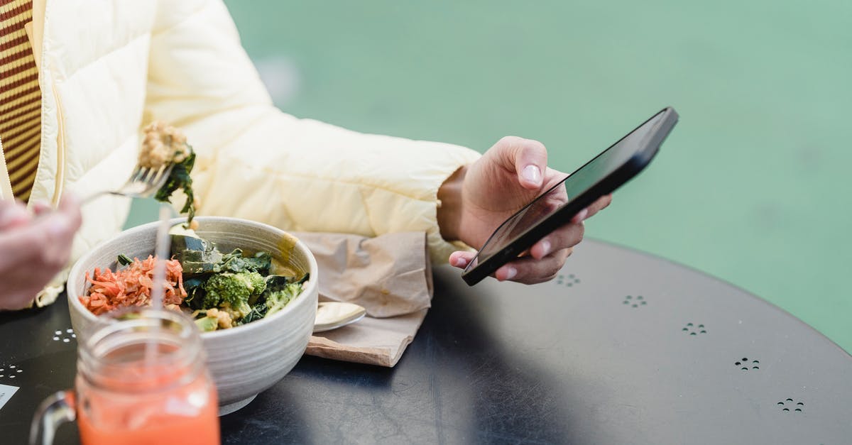 How can I use persimmons in a cooked dish? - Crop woman with smartphone and vegetable salad in street cafeteria