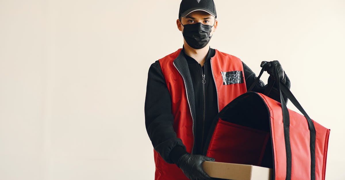 How can we prevent the steaming of tiffin when we put chapatis in? - Young pizza delivery man in uniform and protective mask How can we prevent the steaming of tiffin when we put chapatis in? - Young pizza delivery man in uniform and protective mask