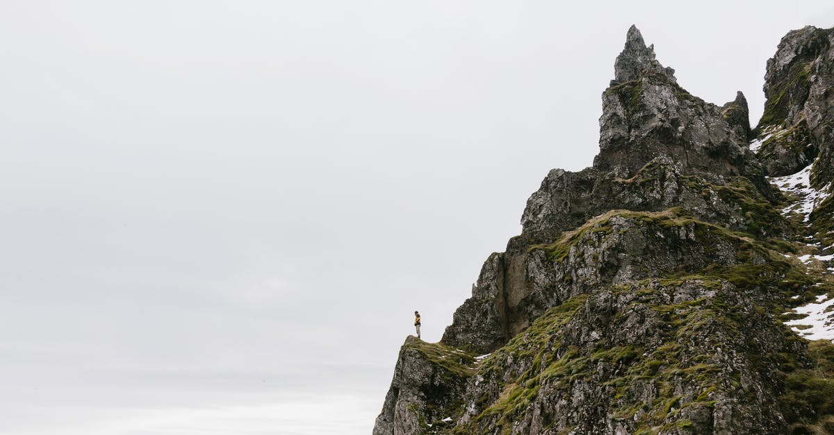 How can you achieve the glazed top in a mille-feuille? - From below of unrecognizable hiker standing alone on edge of rocky cliff against cloudy sky