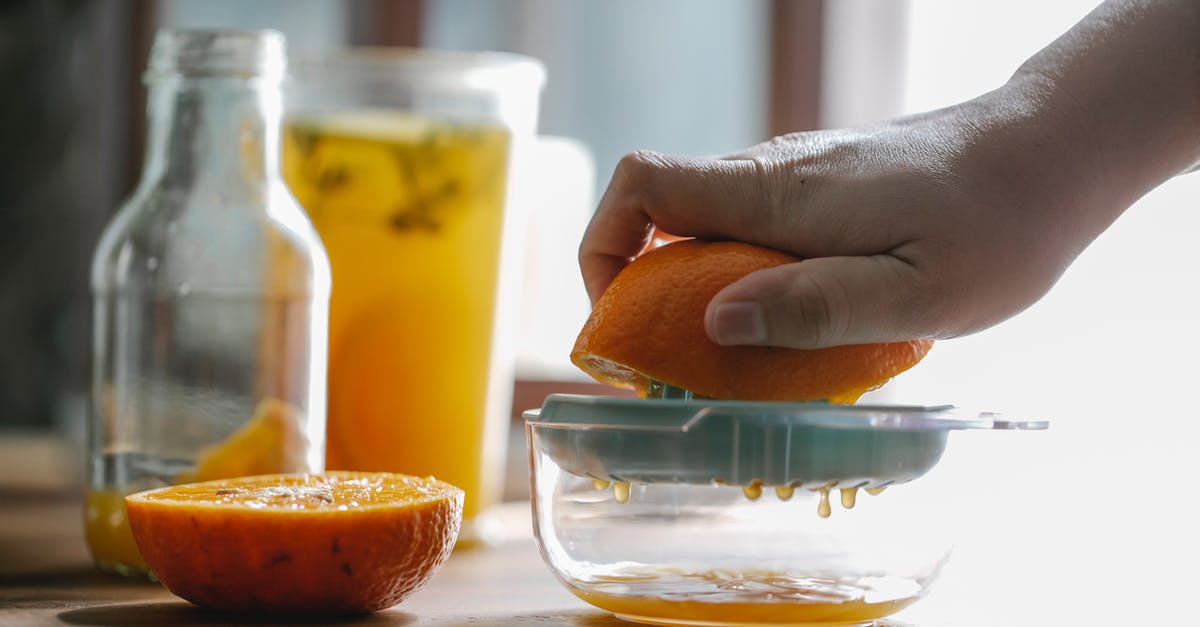 How can you judge whether juice is really freshly squeezed? - Crop anonymous person squeezing half of orange to make homemade juice in kitchen