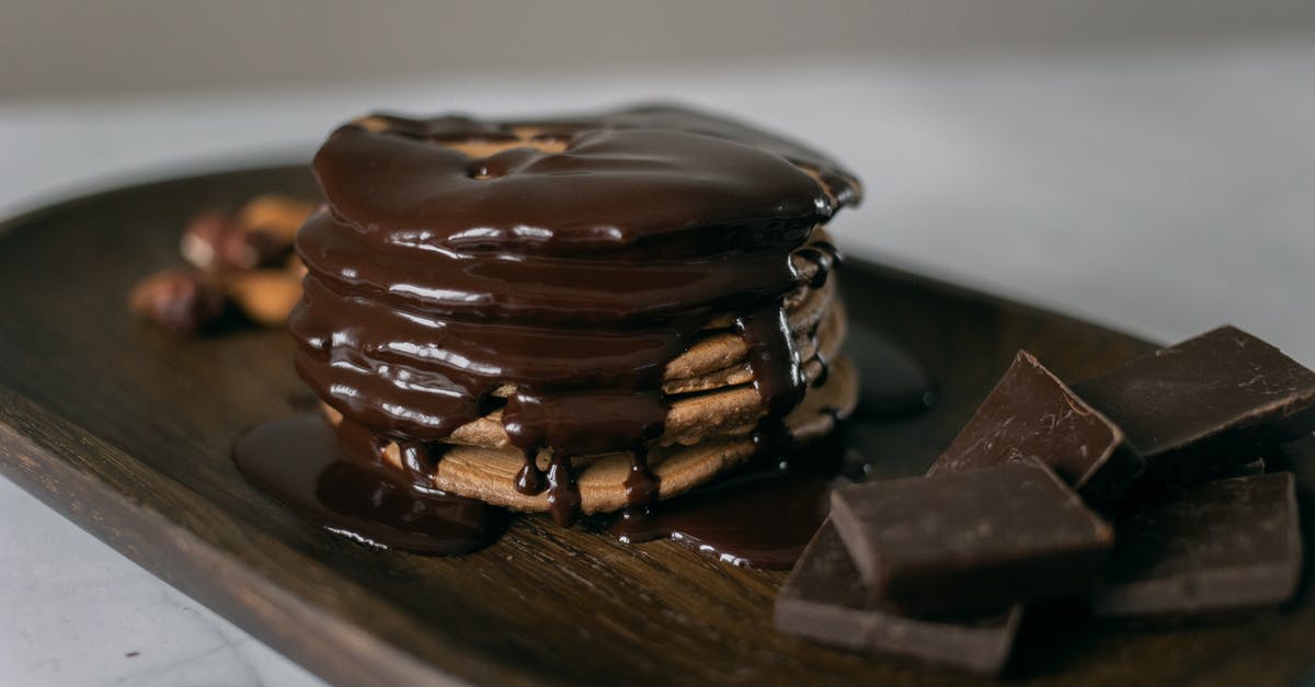 How can you melt chocolate without it getting wet? - Delicious sweet pancakes and melted chocolate on top on wooden board with bar pieces on white table