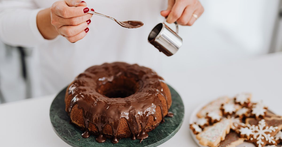 How can you speed up a genoise cake mixing? - Person Holding Stainless Steel Fork and Knife Slicing Chocolate Cake